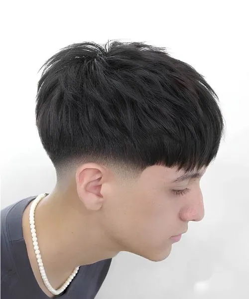 Blowout taper fade haircut featuring faded sides, a tapered neckline, and textured volume on top for a modern hairstyle look.